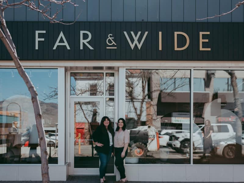 Calli Duncan and Brianne McDaniel stand outside of a storefront with the words "Far & Wide" on it.
