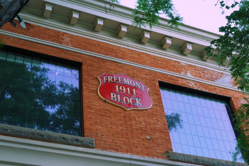 This photo features a brick heritage building with a red sign on the front that reads "Freemont 1911 Block."