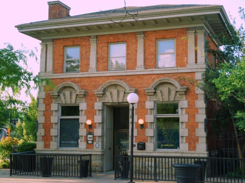 This photo features an old Edwardian style heritage building clad in red brick and stone at the corner of 1st and Victoria Street, downtown Kamloops.