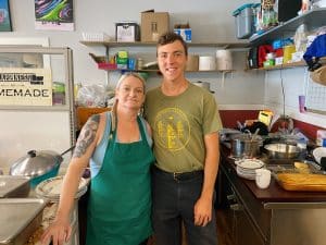 A male and female volunteer stand behind the counter at a resource centre in Kamloops where unhoused folk frequent to escape the heat.