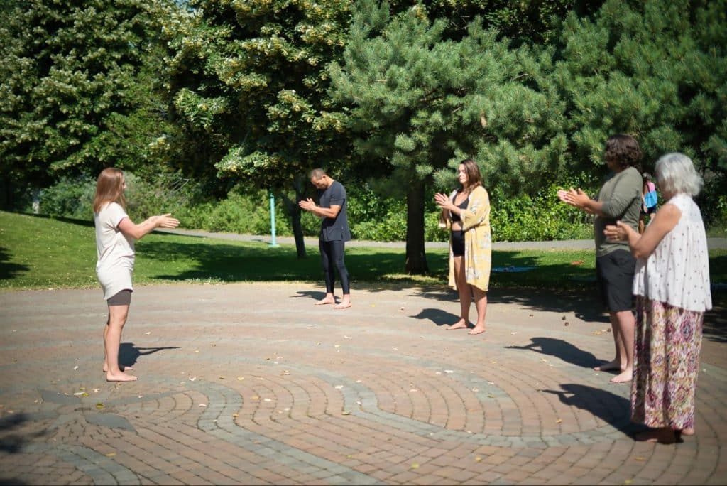 A group practice embodied movement at Riverside Park in July.