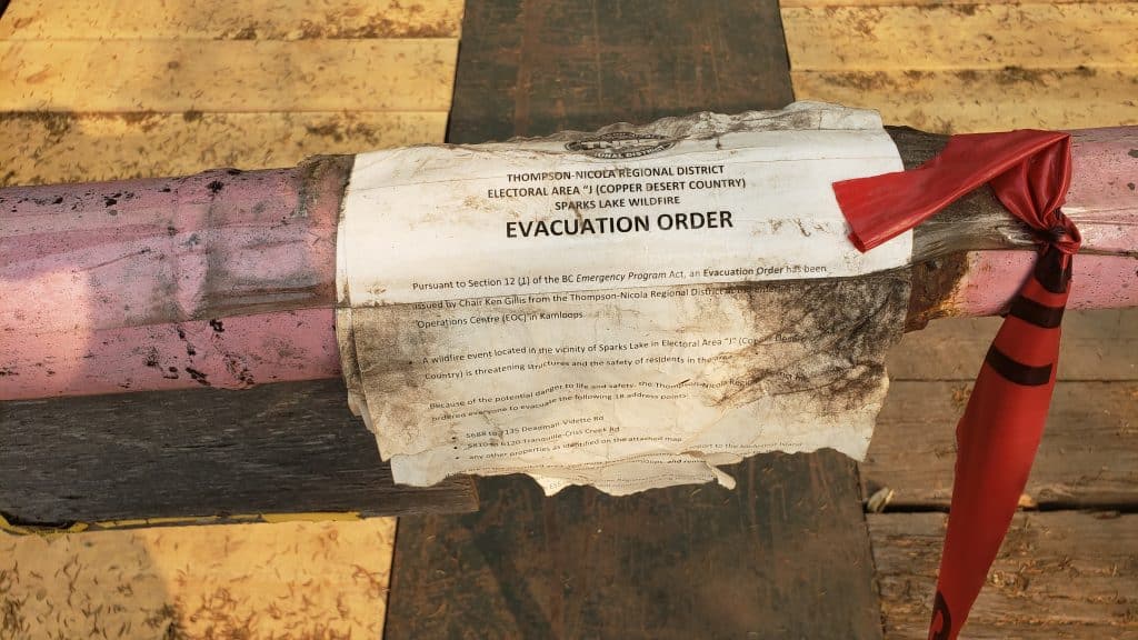A charred evacuation from the 2021 Sparks Lake wildfire is pictured on a gate.