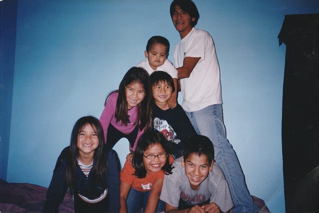 A group of smiling kids pose for a photo in a pyramid.