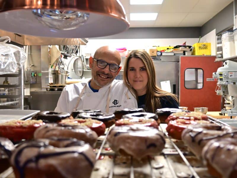 Marcus and Ashley Kharboutli look over a tray of fresh gluten-free doughnuts at Cutting Board Bistro