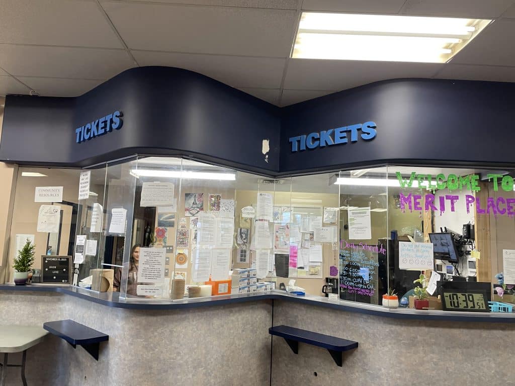 The reception at Merit Place still holds the word "tickets" from its time as a bus depot. Merit Place is written on the reception window.