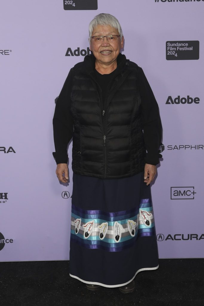 A woman in a ribbon skirt and long sleeve poses at Sundance Film Festival

