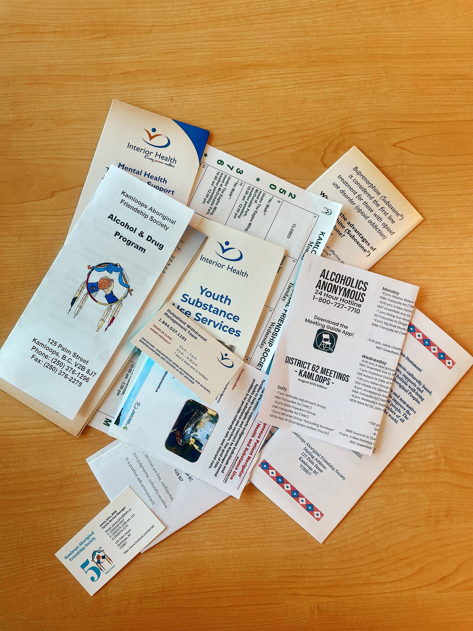 A pile of brochures are shown on a table.