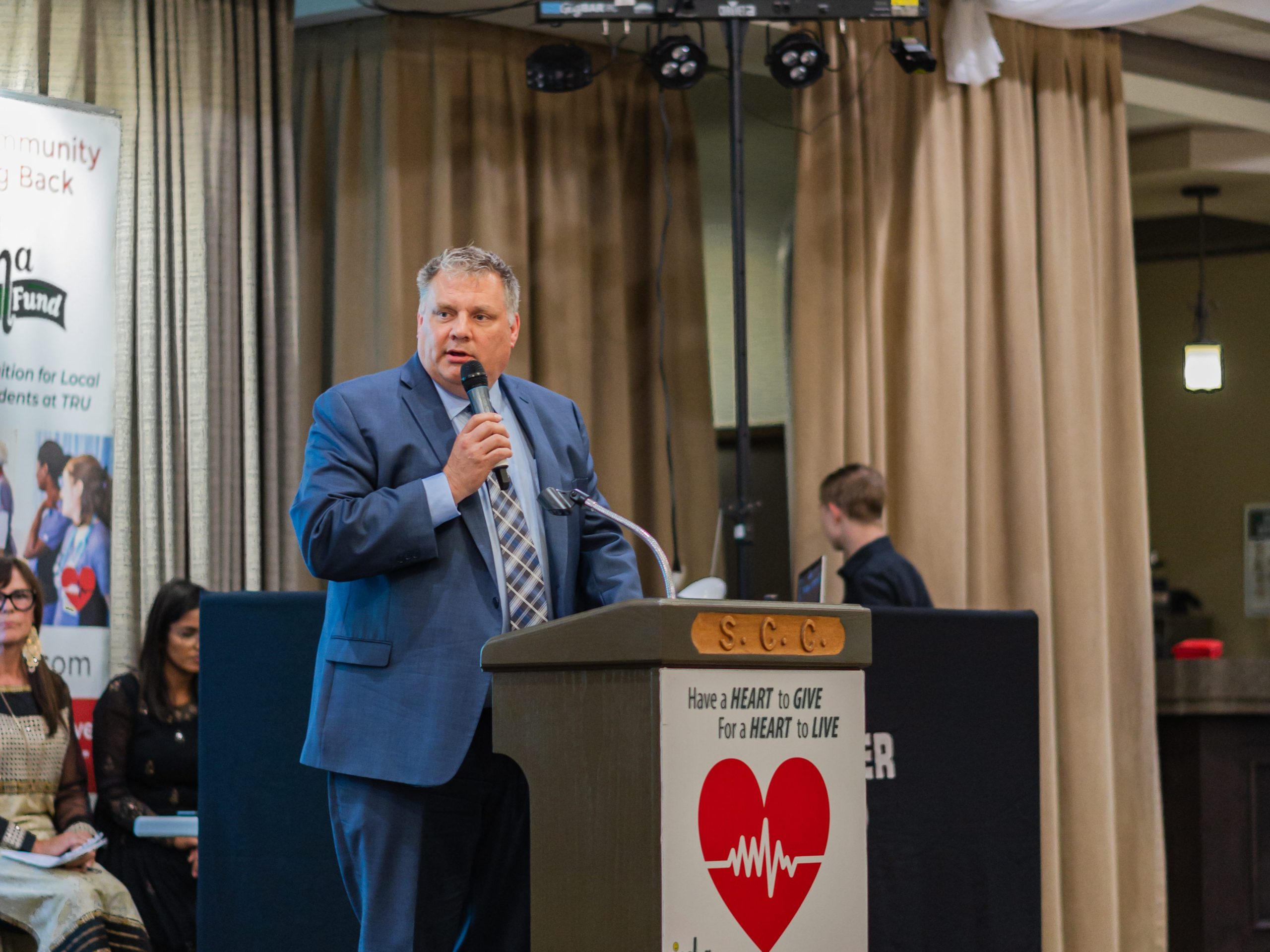 A picture of man holding a microphone giving a speech for the ICCHA wish fund red carpet gala.