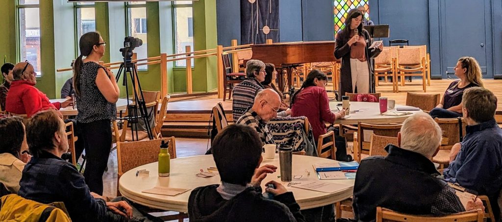 People gathered listening to a speaker. The event is the climate action fest. 