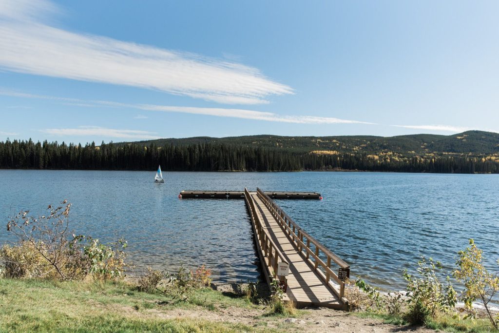 Photo of Lac Le Jeune surrounded by trees and you can see the main dock. Camping sites near Kamloops.