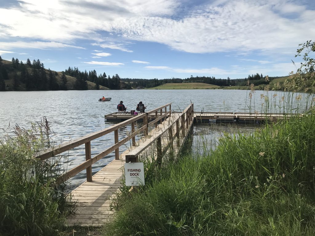 Photo of Edith Lake, there is a dock and montains on the background. Camping sites near Kamloops