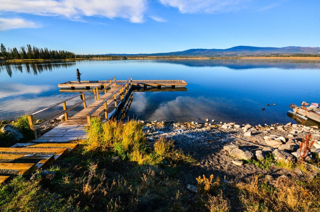 Photo of Tunkwa Lake, there is a dock and montains on the background. Camping sites near Kamloops