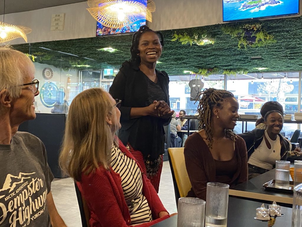 Sally Martin is in the middle of the picture surrounded by other people sitting at the dinner table organized by a Valid Dreams Foundation.